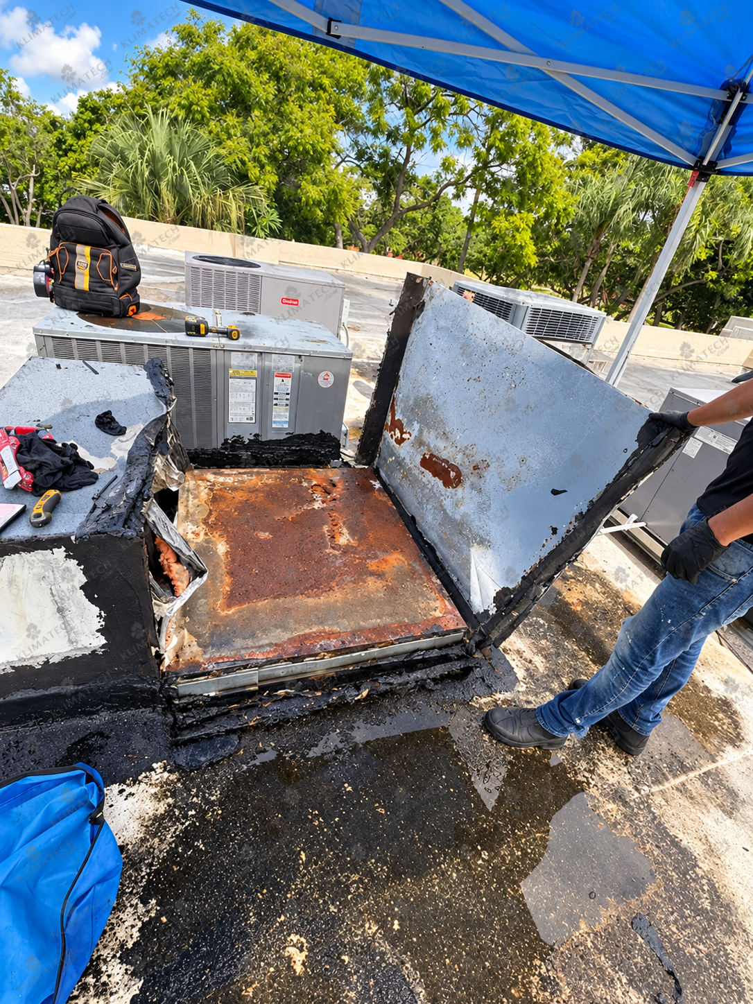 HVAC technician inspecting a severely rusted AC component for signs of damage and needed repairs.